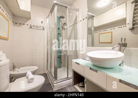 Moderno bagno con piano in vetro e doccia idromassaggio in affitto appartamento a breve termine Foto Stock