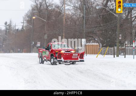 Un veicolo privato per spazzaneve di un lavoratore autonomo guida in Victoria Park Avenue durante una tempesta di neve invernale a Toronto, Canada Foto Stock