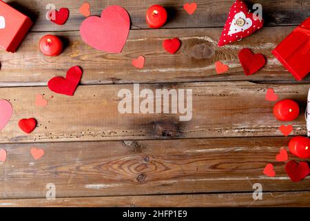 Candele rosse brucianti con decorazioni a forma di cuore da scatola regalo su tavola di legno con spazio copia Foto Stock