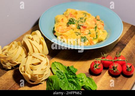Pasta appetitosa con gamberi, pomodoro ciliegia. Cucina italiana. Foto Stock