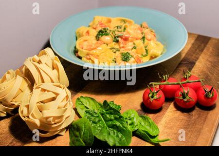 Pasta appetitosa con gamberi, pomodoro ciliegia. Cucina italiana. Foto Stock