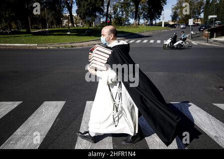 Cecilia Fabiano/LaPresse Ottobre 28 , 2020 Roma News : un monaco con libri e maschera attraversa piazza della greca nel Pic : il monaco sul passaggio pedonale Foto Stock