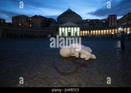 Un ragazzo ha visto stare vicino alla statua di Jago nella piazza. Una statua raffigurante un bambino abbandonato, opera dell'artista Jago (Jacopo Cardillo) è stata lasciata in Piazza Plebiscito, Napoli, all'alba. Il nome della statua “guardare giù” è un invito a guardare le persone povere e fragili. Valeria Ferraro/LaPresse Foto Stock