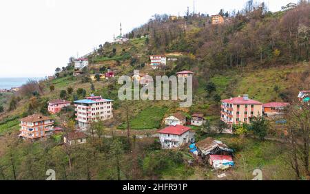 Paesaggio di montagna della città di Surmene, Trabzon, Turchia. Le case abitanti sono sulla costa del Mar Nero di giorno Foto Stock