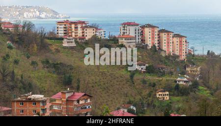 Paesaggio di montagna della città di Surmene, Trabzon, Turchia. Le case abitate e gli appartamenti si trovano sulla costa del Mar Nero di giorno Foto Stock