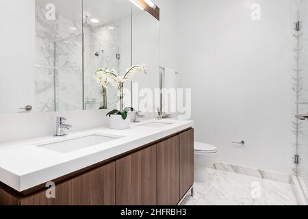 Bagno attico di lusso con lavandino in legno e piastrelle in marmo bianco. Elegante suite dell'hotel. Design moderno e contemporaneo. Foto Stock