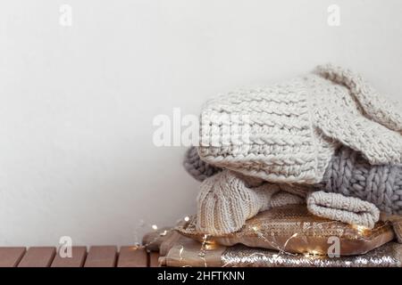 Primo piano di articoli a maglia piegati in modo ordinatamente di colore pastello su uno sfondo chiaro. Foto Stock