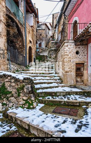 Scalini, vicoli e tetti innevati nel piccolo paese montano di Secinaro. Provincia di l'Aquila, Abruzzo, Italia, europa Foto Stock