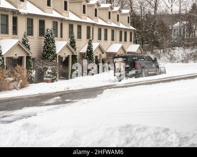 Morgantown, WV - 17 gennaio 2022: Camion con lama spazzaneve che sgomenta la strada residenziale dopo la tempesta di neve Foto Stock