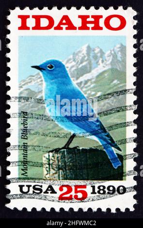 STATI UNITI D'AMERICA - CIRCA 1990: Un francobollo stampato negli Stati Uniti mostra Mountain Bluebird e Sawtooth Mountains, Idaho state Centenary, circa 1990 Foto Stock