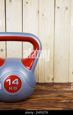 un kettlebell sportivo su sfondo di legno. Stile di vita sano Foto Stock