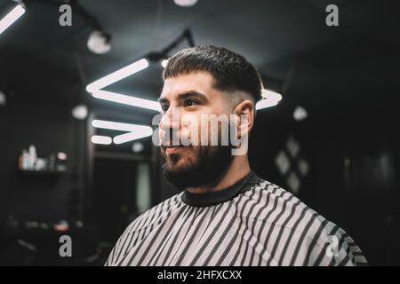 Giovane cliente uomo al barbiere ottenere haircut ritratto cliente Hipster Foto Stock