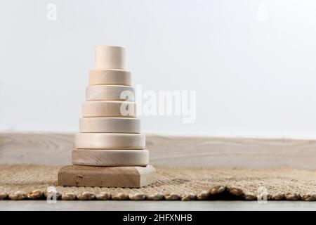 Piramide di legno su un tappeto di vimini, ombra da una palma. Spazio vuoto per il testo. Foto Stock