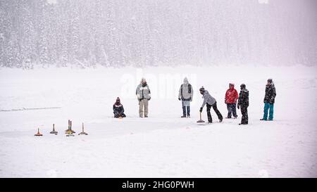 Lago Louise, Canada - Dicembre 22 2021: Le persone che giocano curando sul Lago Louise ghiacciato in Alberta Canada Foto Stock