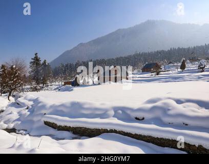 Gennaio 14, 2022, Srinagar, Jammu e Kashmir, India: Vista generale di un villaggio innevato dopo nevicate pesanti in un villaggio di Budgam distretto di Indian-Kashmir. Il Kashmir è attualmente sotto la morsa di 40 giorni di periodo più rigido d'inverno, noto localmente come ''˜Chillai Kalan, che ha avuto inizio dal dicembre 21. Segue un ''˜Chillai Khurd' lungo 20 giorni e un ''˜chilla Bachhaâ lungo 10 giorni (immagine di credito: © Sajad Hameed/Pacific Press via ZUMA Press Wire) Foto Stock