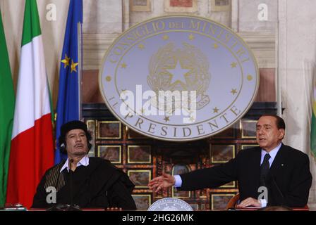 Il Premier italiano Silvio Berlusconi, a destra, parla con il leader libico Moammar Gadhafi prima dell'inizio di una conferenza stampa congiunta a Villa Madama di Roma, Gadhafi è in visita ufficiale in Italia per tre giorni. Foto Stock