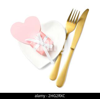 Bella piastra a forma di cuore e posate su sfondo bianco Foto Stock
