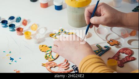 La donna invecchiata dipinge su carta. Il concetto di hobby, relax. Primo piano con le mani Foto Stock