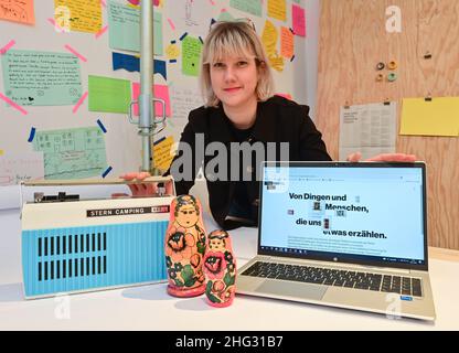 10 gennaio 2022, Brandeburgo, Eisenhüttenstadt: Sabrina Kotzian, dipendente del Museo Utopia e della vita quotidiana, mostra una stella camping radio da GDR Times, matryoshka (matryoshka) e un laptop con la pagina iniziale della piattaforma di partecipazione digitale. Il Museo Utopia e la vita quotidiana di Eisenhüttenstadt ha progettato una nuova piattaforma partecipativa digitale, l'anno scorso, per condividere ricordi e storie di oggetti. Offre una panoramica delle collezioni di cultura e arte di tutti i giorni della RDT. La piattaforma invita le persone a condividere esperienze, ricordi e storie con cui i visitatori si associano Foto Stock