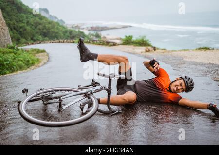Il ciclista esausto cadde sulla strada Foto Stock