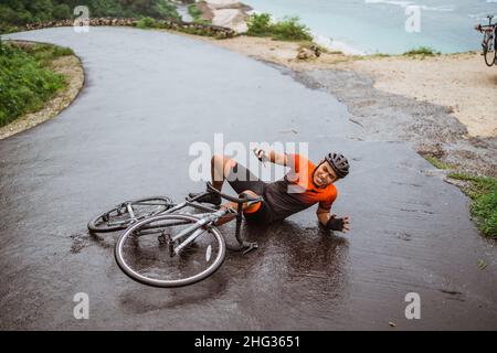Il ciclista esausto cadde sulla strada Foto Stock