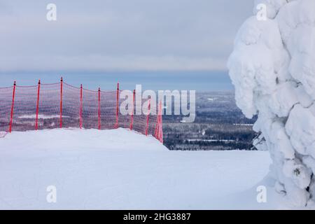 Rete di sicurezza rossa per lo sci su una montagna innevata in una stazione sciistica in Finlandia Foto Stock