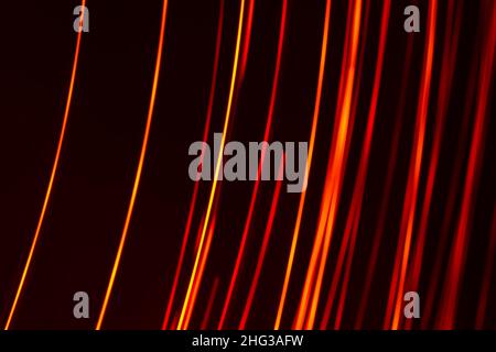 Linee verticali diagonali di colore rosso chiaro su sfondo scuro. Sfondo astratto. Foto Stock