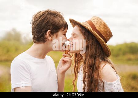 I bambini mangiano gelato all'aperto. Fratelli e sorelle ridono e mangiano gelato nel villaggio in estate. Foto Stock