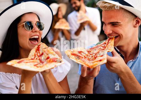 Buon gruppo di persone che mangiano pizza all'aperto, si godono insieme. Foto Stock