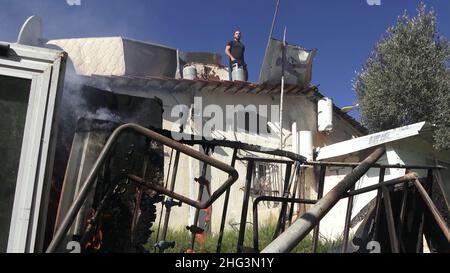 Gerusalemme, Israele. 17th Jan 2022. I palestinesi si barricano con i canister sul tetto della casa di famiglia di Salhiya, minacciando di farlo esplodere dopo che i membri delle forze di sicurezza israeliane circondano la casa di famiglia di un palestinese, Salhiya, che è richiesto essere liberato nel quartiere di Sheikh Jarrah il 17 gennaio 2021 a Gerusalemme, Israele. La famiglia di Salhiya si trova di fronte a una minaccia di sfratto dal 2017, quando la terra in cui si trova la sua casa era destinata alla costruzione scolastica. Il quartiere palestinese di Sheikh Jarrah è attualmente il centro di una serie di controversie di proprietà tra P. Foto Stock