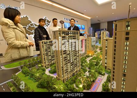 QINGZHOU, CINA - 21 DICEMBRE 2021 - i compratori domestici osservano i tavoli di sabbia ad un ufficio di vendite del bene immobile nella città di Qingzhou, provincia di Shandong della Cina orientale, Foto Stock