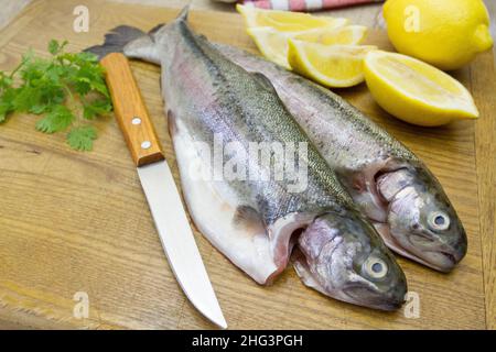 trota cruda intera su un asse di legno Foto Stock