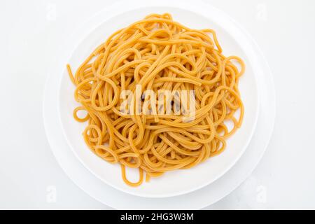 spaghetti interi di grano in un piatto bianco Foto Stock