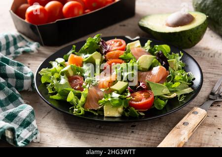 Insalata di salmone e avocado su tavola rustica in legno Foto Stock