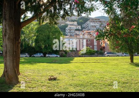 Montenegro - Budva: 6 settembre 2021: Parco pubblico nella città di Budva con edifici residenziali sulla collina. Città turistica con splendidi giardini verdi Foto Stock