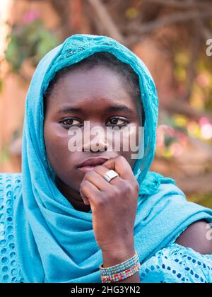 Senegal, Africa - Jan, 2019: Ritratto di una bella donna senegalese in un costume tradizionale chiamato 'boubou' e un altalena sulla sua testa Foto Stock