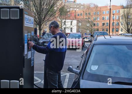 Il conducente paga per addebitare l'auto presso un punto di ricarica EV a bristol Inghilterra Foto Stock