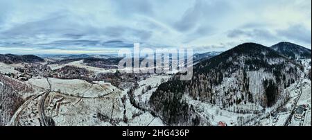 Strada tortuosa attraverso la montagna coperta di foresta, paesaggio invernale con strada tortuosa tra campagna, vista aerea Foto Stock