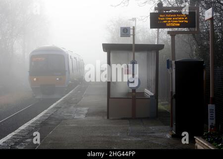 Un servizio di Chiltern Railways che arriva alla stazione ferroviaria di Bearley nella nebbia invernale, Warwickshire, Inghilterra, Regno Unito Foto Stock
