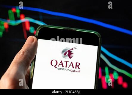 Cina. 09th Dic 2021. In questa illustrazione della foto il vettore di bandiera di proprietà dello stato del Qatar, il logo Qatar Airways visto su uno smartphone con un grafico di indice di borsa economica sullo sfondo. (Foto di Budrul Chukrut/SOPA Images/Sipa USA) Credit: Sipa USA/Alamy Live News Foto Stock