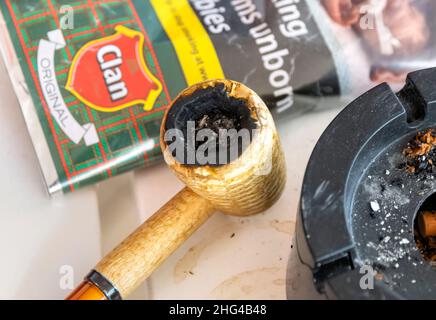 Pipa su tavola bianca di legno con tabacco e posacenere Foto Stock