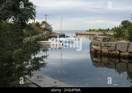 Piccola insenatura rocciosa a Gloucester, massa che si rivolge a nautica e pesca. Pareti rocciose sostengono una piccola entrata qui. Viste incantevoli. Per lo più barche da pesca. Foto Stock