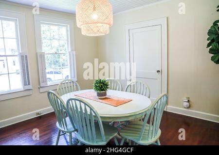 Una piccola sala da pranzo con un'illuminazione in rattan di tendenza Foto Stock