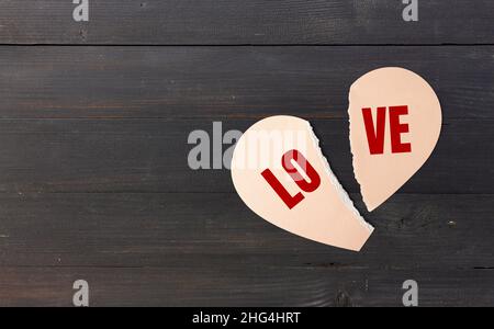 cuore di carta rotto. buon san valentino sfondo. oggetto festivo decorativo, carta a forma di cuore su sfondo di legno nero. biglietto d'auguri. vacanza Foto Stock