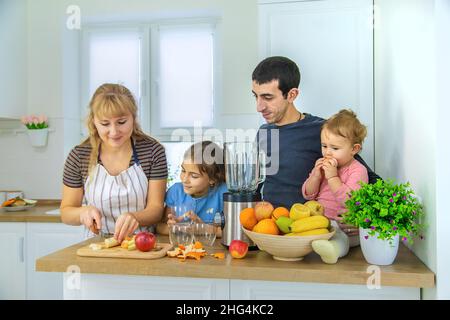 La famiglia sta facendo i frullati nella cucina. Messa a fuoco selettiva. Foto Stock