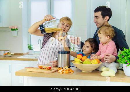 La famiglia sta facendo i frullati nella cucina. Messa a fuoco selettiva. Foto Stock