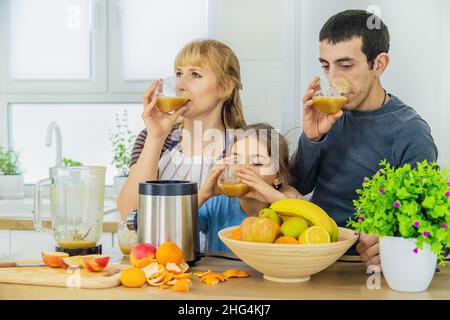 La famiglia sta facendo i frullati nella cucina. Messa a fuoco selettiva. Foto Stock