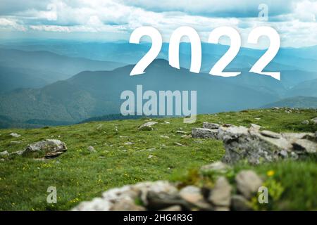 2022 viaggio su strada di Capodanno e concetto di visione del futuro . Paesaggio naturale con valle di campagna sulla collina erbosa che porta avanti per felice Foto Stock