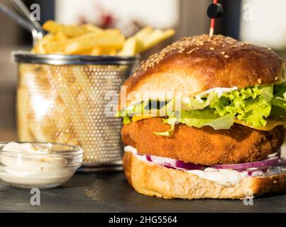 Hamburger di pollo croccante con patatine fritte e salsa di maionese pronto a mangiare Foto Stock