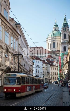 PRAGA, REPUBBLICA CECA - 5 giugno 2018: Un vecchio tram sulle strade strette della città con una cupola architettonica della Chiesa di San Nicola Foto Stock